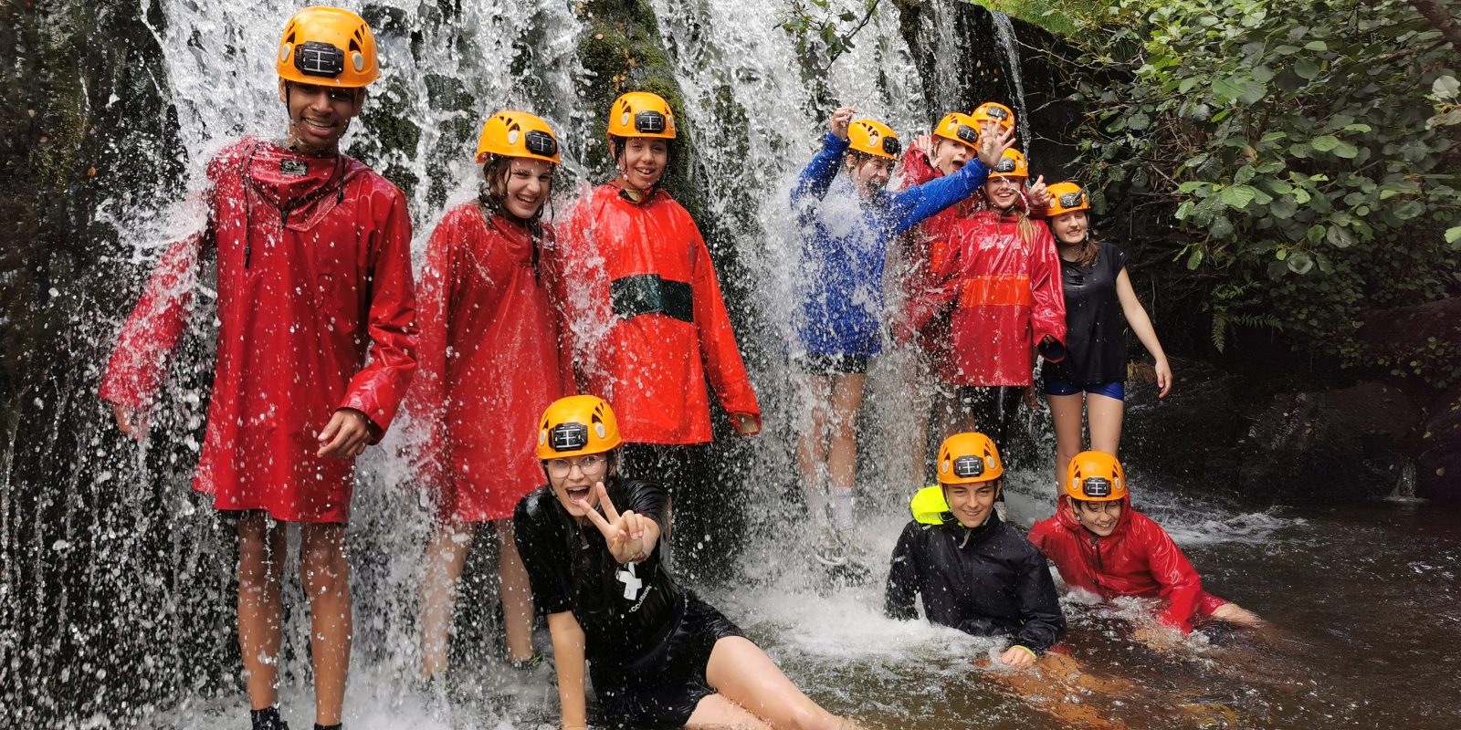 AAE students standing under waterfall