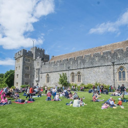 Crowds of people sat in front of St Donat's Castle