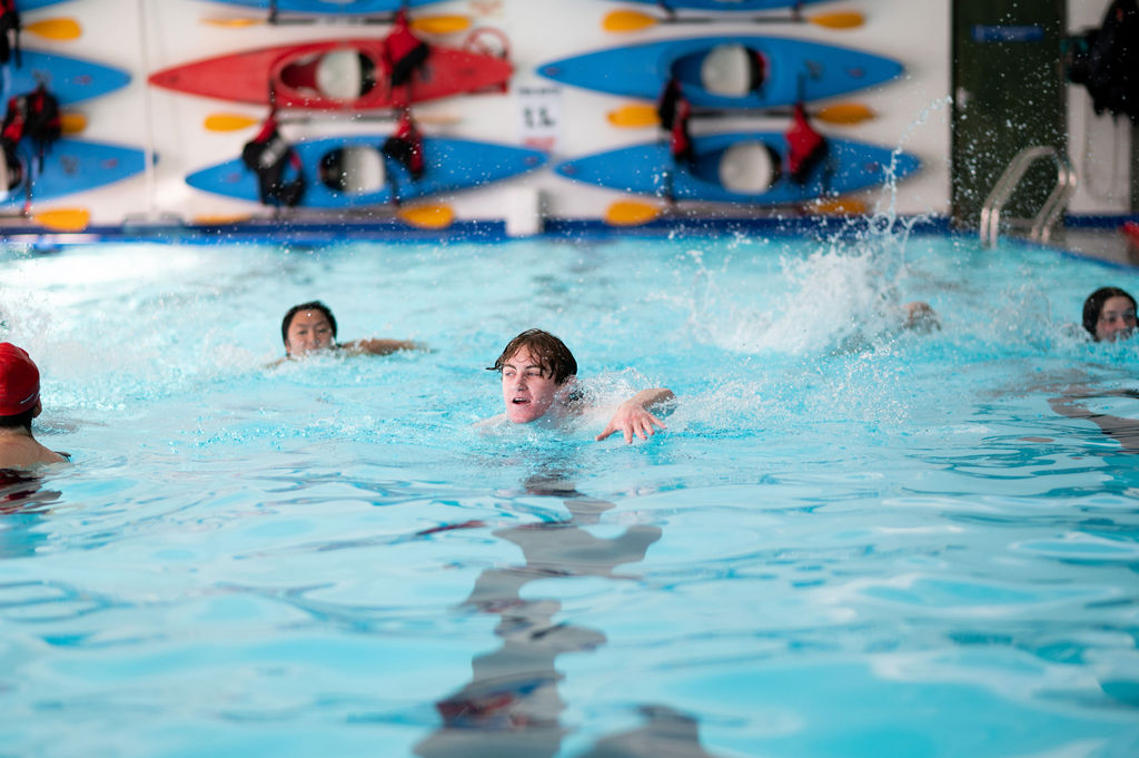 student swimming in indoor pool