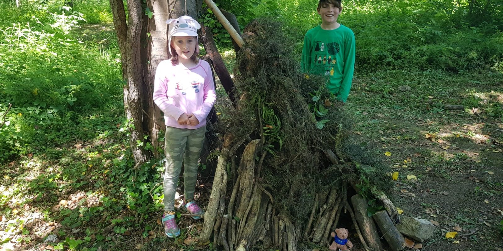 Kids with built woodland shelter