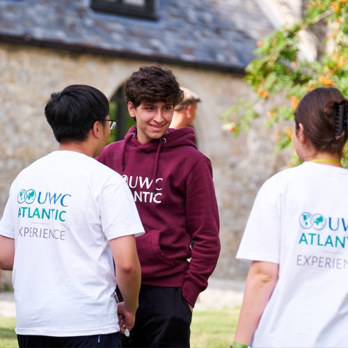 Three participants of the GLE programme outdoors talking in a discussion