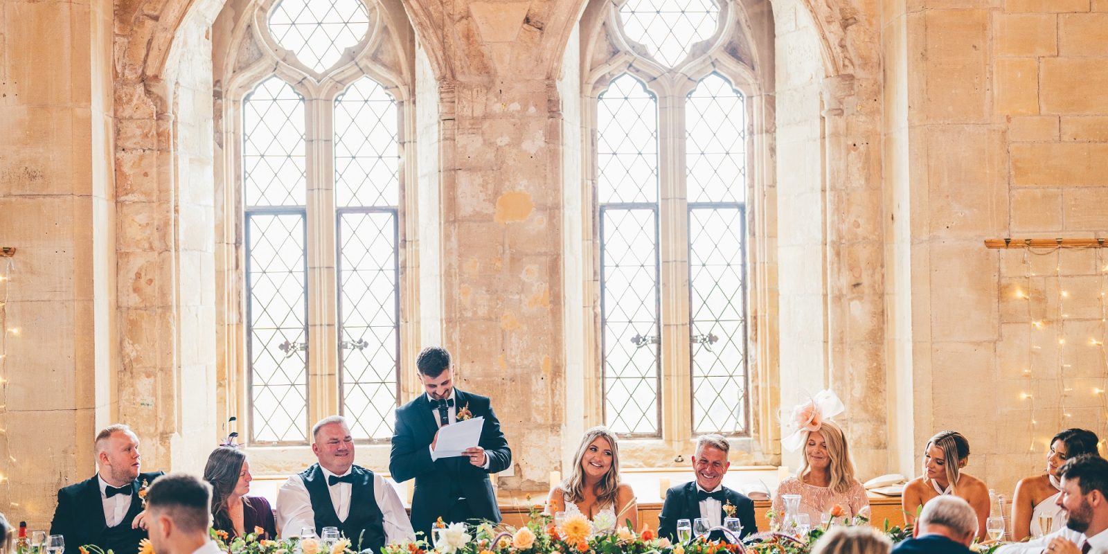 Wedding speeches with the grand windows of St Donat's Castle in the background.
